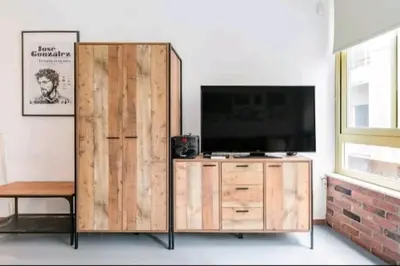 a wooden entertainment center with a television on top of it at Explore a New Arts District from a Hip Studio Flat in Athens