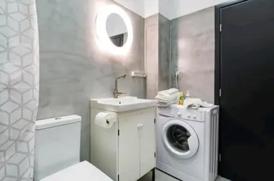 a bathroom with a washing machine and a sink at Explore a New Arts District from a Hip Studio Flat in Athens