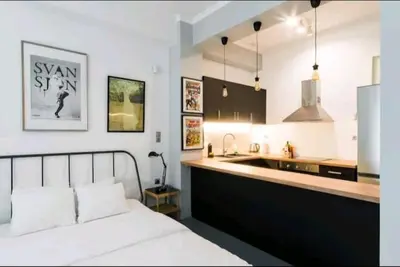 a bedroom with a white bed and a kitchen at Explore a New Arts District from a Hip Studio Flat in Athens