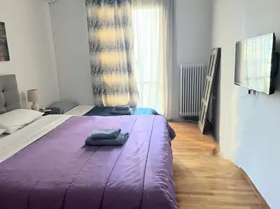 a bedroom with a large bed with a purple blanket at Eχquisite apt in Acropolis-plaka/vaccinatedHost in Athens