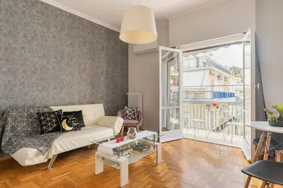 a living room with a couch and a large window at Eχquisite apt in Acropolis-plaka/vaccinatedHost in Athens