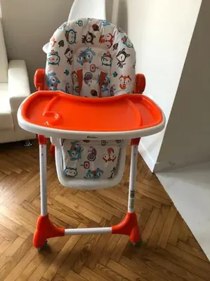 an orange and white high chair sitting on a wooden floor at Downtown Athens-Plaka Skoufou Apt/VaccinatedHost in Athens