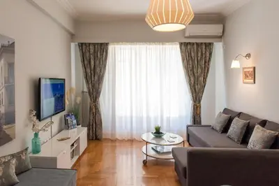 a living room with a couch and a tv at Blue Ark Acropolis Light in Athens