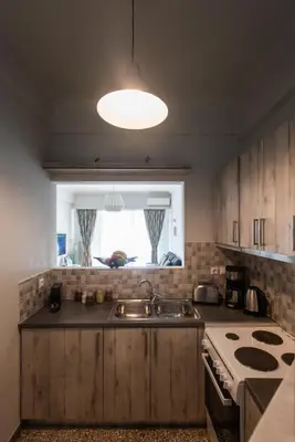 a kitchen with a sink and a stove and a window at Blue Ark Acropolis Light in Athens