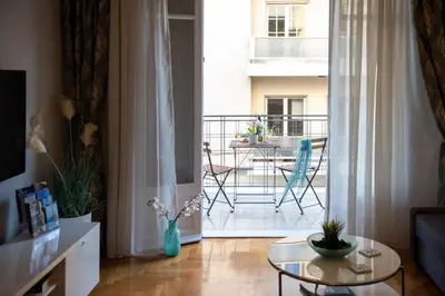 a living room with a glass table and a balcony at Blue Ark Acropolis Light in Athens