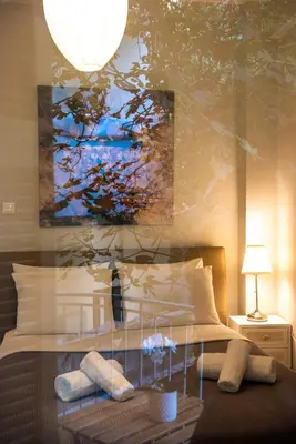 a bedroom with a bed with a painting on the wall at Blue Ark Acropolis Light in Athens