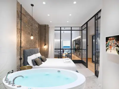 a bedroom with a large bed and a tub at 5 star lux suite in Kolonaki. in Athens