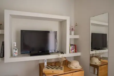 a living room with a tv and a chess board and a mirror at Cosy Penthouse With Terrace Near Metro Station in Athens