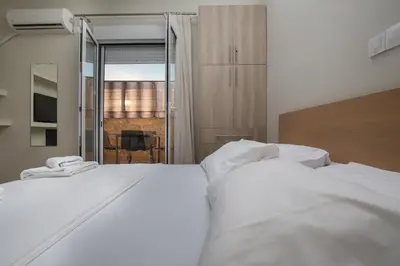 two white beds in a room with a window at Cosy Penthouse With Terrace Near Metro Station in Athens