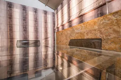 a bathroom with a shower with a stone wall at Cosy Penthouse With Terrace Near Metro Station in Athens