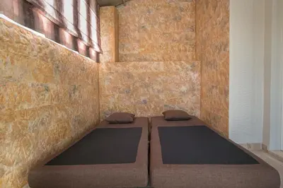 a room with two beds in front of a brick wall at Cosy Penthouse With Terrace Near Metro Station in Athens