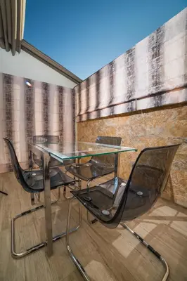 a glass table and two chairs in a room at Cosy Penthouse With Terrace Near Metro Station in Athens