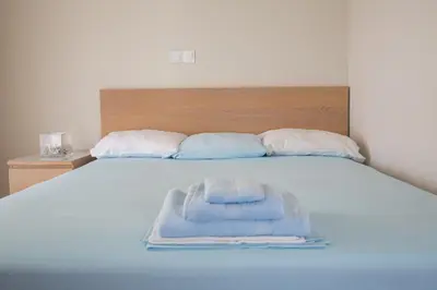 a bed with a pile of towels on it at Cosy Penthouse With Terrace Near Metro Station in Athens