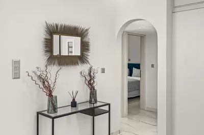 a hallway with a console table and a mirror at BillyMare central Glyfada apartment in Athens