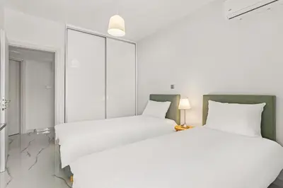 two beds in a white room with white walls at BillyMare central Glyfada apartment in Athens