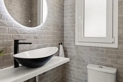 a bathroom with a bowl sink and a toilet at BillyMare central Glyfada apartment in Athens