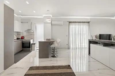 a kitchen with white walls and white floors and a table at BillyMare central Glyfada apartment in Athens