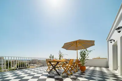 a patio with a table and an umbrella on a roof at Luxurious Apartment with Big Sea View Terrace - Central Location in Athens
