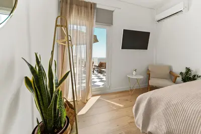 a bedroom with a bed and a plant and a balcony at Luxurious Apartment with Big Sea View Terrace - Central Location in Athens
