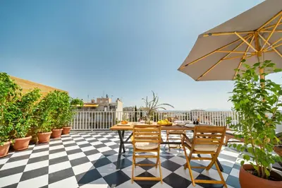 a patio with a table and chairs on a roof at Luxurious Apartment with Big Sea View Terrace - Central Location in Athens