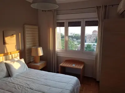 a bedroom with a bed and a window at ENILION ATHENS , CITY CENTER WITH VIEW TO ACROPOLIS in Athens