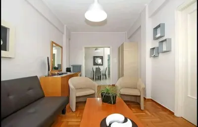 a living room with a couch and a table at ENILION ATHENS , CITY CENTER WITH VIEW TO ACROPOLIS in Athens