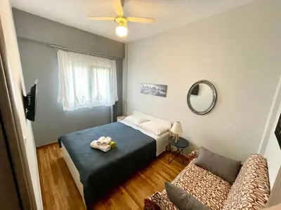 a bedroom with a bed and a couch and a mirror at Luxury Flat in Hilton, 3' from metro, VFM! in Athens