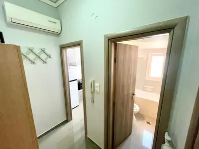 a bathroom with a door leading to a toilet at Luxury Flat in Hilton, 3' from metro, VFM! in Athens