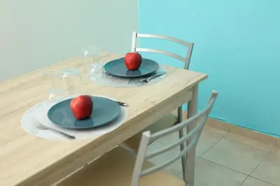 two red apples on blue plates on a wooden table at Nikea apartment near Piraeus port and metro st I in Piraeus