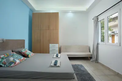 a bedroom with a bed and a couch and a window at Nikea apartment near Piraeus port and metro st I in Piraeus