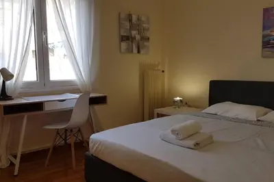 a bedroom with a bed and a desk and a window at Blue Apartment - Athens Center, 4 BD, 2 BATH in Athens