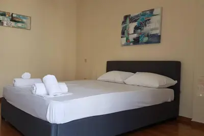 a bedroom with a bed with white sheets and pillows at Blue Apartment - Athens Center, 4 BD, 2 BATH in Athens