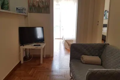 a living room with a couch and a flat screen tv at Blue Apartment - Athens Center, 4 BD, 2 BATH in Athens