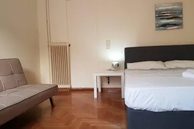 a bedroom with a bed and a couch and a table at Blue Apartment - Athens Center, 4 BD, 2 BATH in Athens