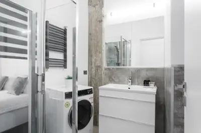 a white bathroom with a washing machine and a sink at Industrial 1BR Apartment in Ampelokipoi Area by UPSTREET in Athens