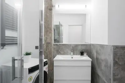 a white bathroom with a sink and a mirror at Industrial 1BR Apartment in Ampelokipoi Area by UPSTREET in Athens