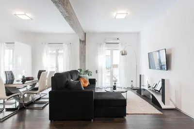 a living room with a black couch and a table at Industrial 1BR Apartment in Ampelokipoi Area by UPSTREET in Athens