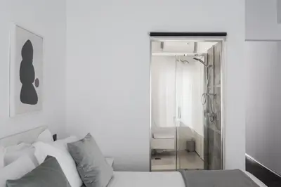 a white bedroom with a shower and a bed at Industrial 1BR Apartment in Ampelokipoi Area by UPSTREET in Athens