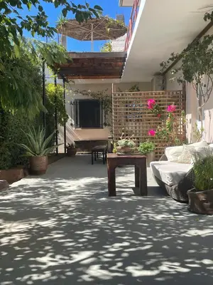 a patio with a table and some potted plants at the garden house in Dhaskalión
