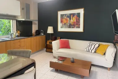 a living room with a white couch and a kitchen at the garden house in Dhaskalión