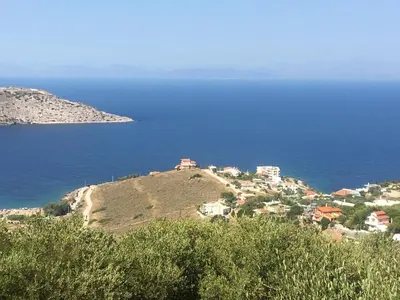 a group of houses on a hill next to the ocean at the garden house in Dhaskalión