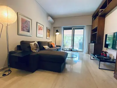 a living room with a couch and a table at Athens Riviera Garden Views Apartment #Unoblu in Athens