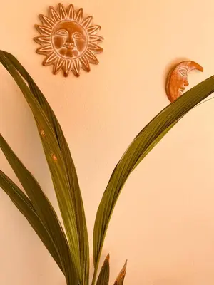 a sun and a plant on a wall at Athens Riviera Garden Views Apartment #Unoblu in Athens