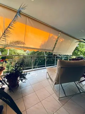 a patio with an umbrella and a couch and chairs at Athens Riviera Garden Views Apartment #Unoblu in Athens