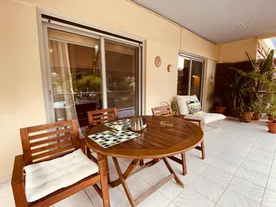 a dining room with a wooden table and chairs at Athens Riviera Garden Views Apartment #Unoblu in Athens