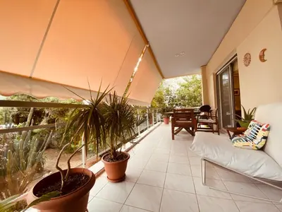 a living room with potted plants on a balcony at Athens Riviera Garden Views Apartment #Unoblu in Athens
