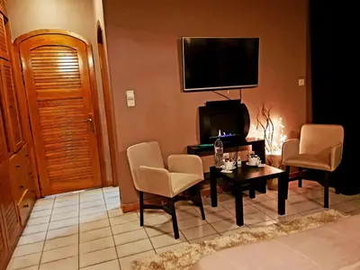 a living room with a table and chairs and a television at Kouro's private room! in Piraeus