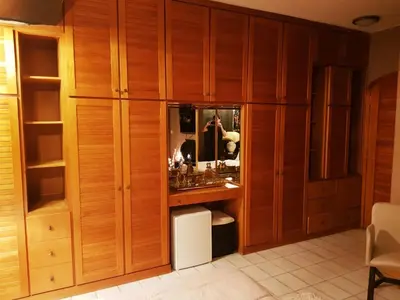 a dressing room with wooden cabinets and a mirror at Kouro's private room! in Piraeus