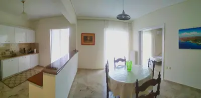 a kitchen with a table and a dining room at Vangelis apartment near Athens Airport in Spáta