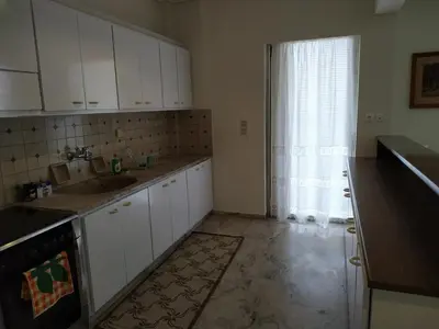 a kitchen with white cabinets and a sink and a window at Vangelis apartment near Athens Airport in Spáta
